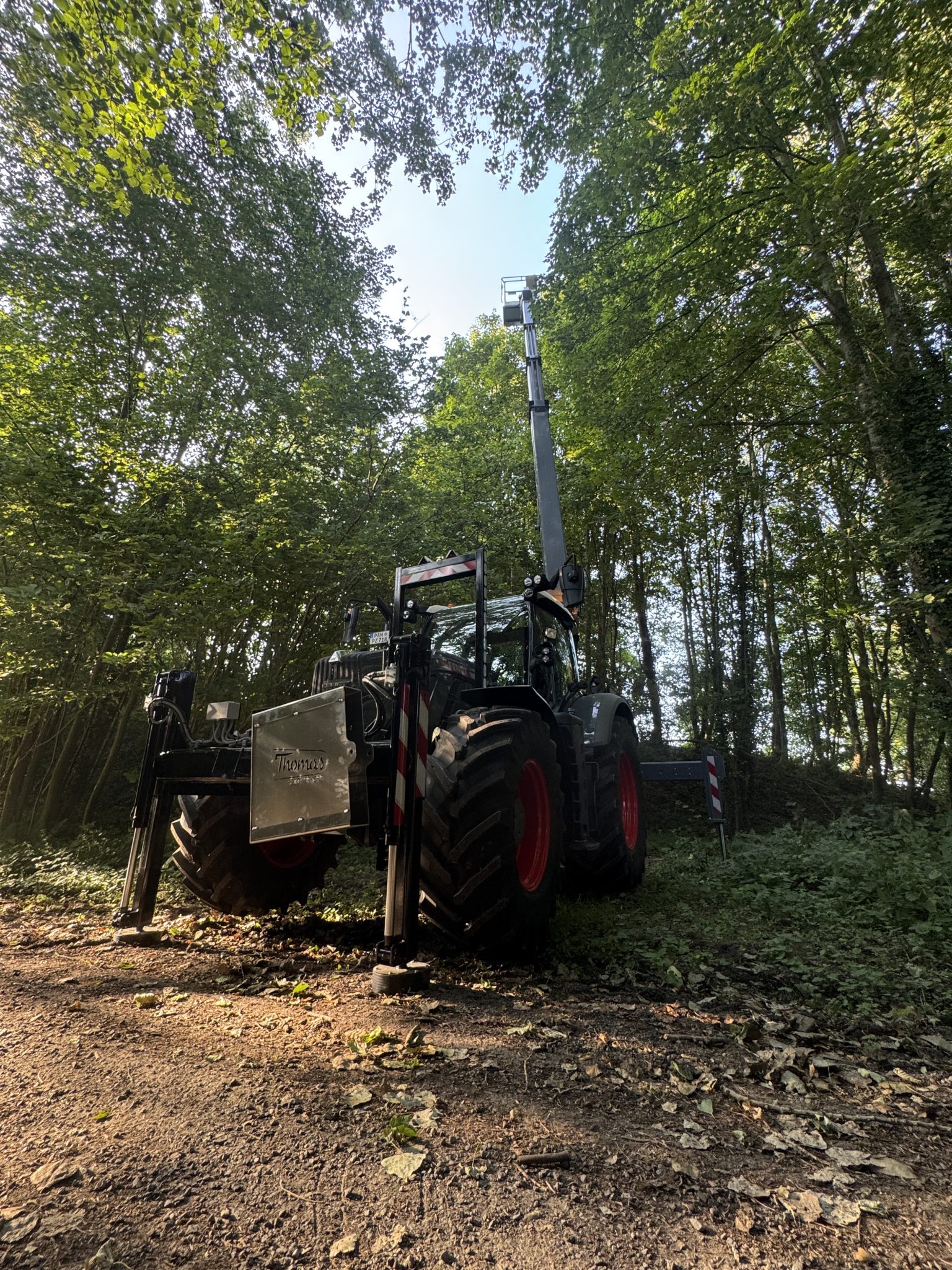 Thomas & Ufkes 240 PTO hoogwerker op Fendt tractor met arm verticaal uitgestrekt in bos