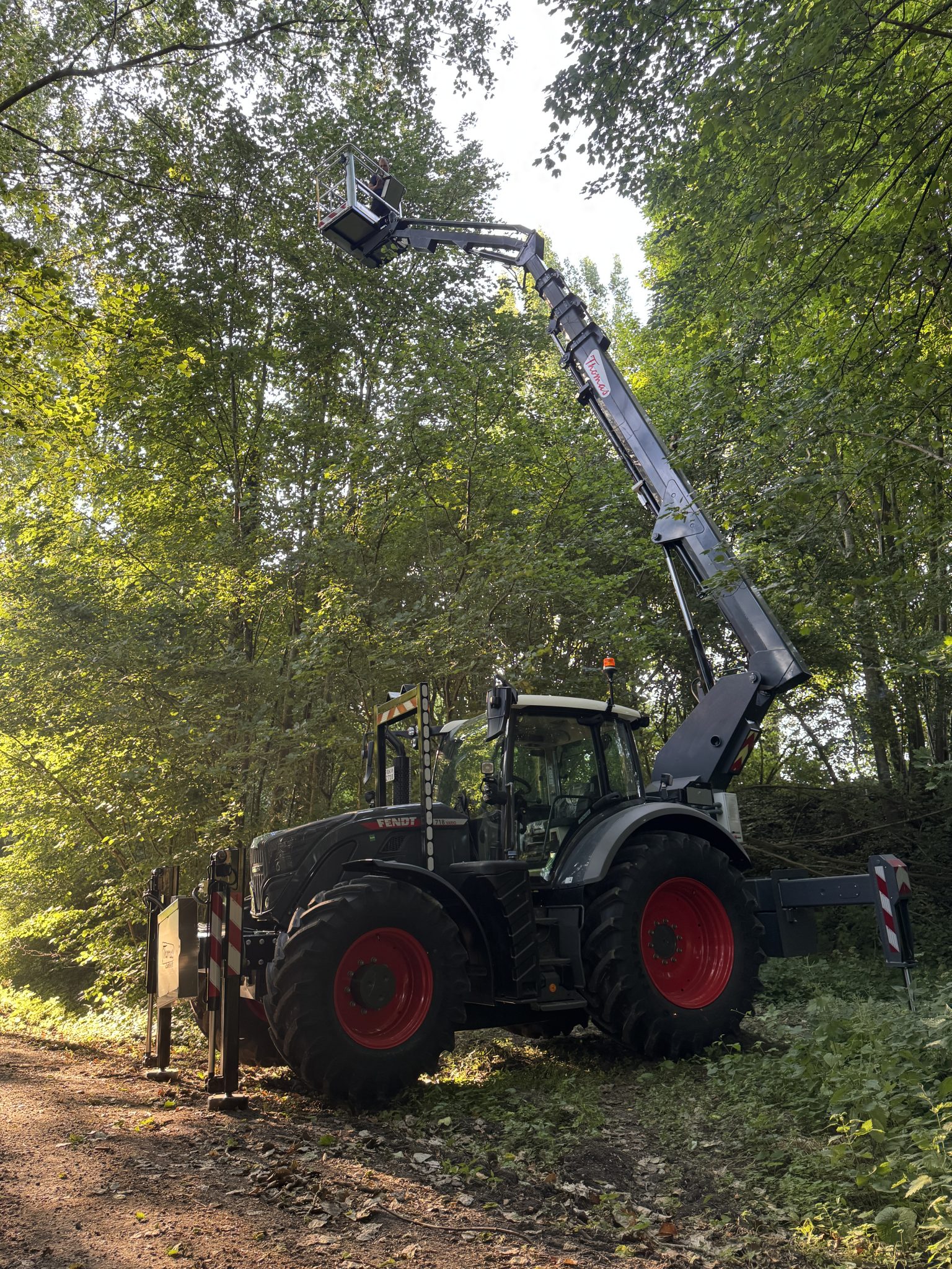 Thomas & Ufkes 240 PTO hoogwerker op Fendt tractor met uitgestrekte arm in bos