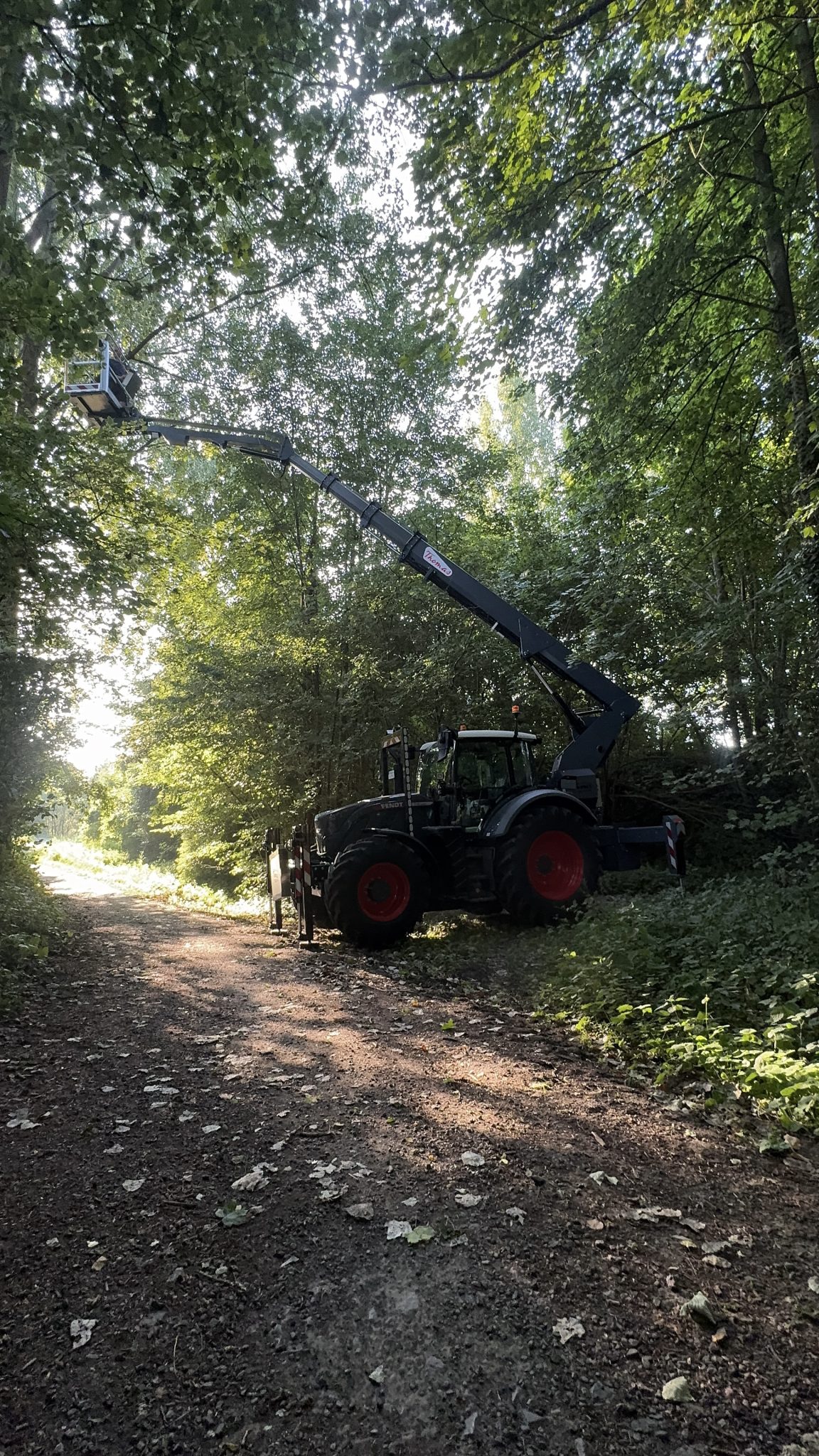 Thomas & Ufkes 240 PTO hoogwerker op tractor in actie langs bospad met arm volledig uitgestrekt